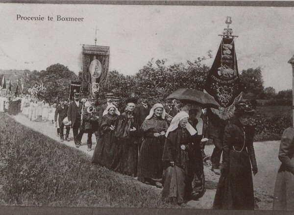 Een processie trekt door de Boxmeerse velden in de volle zon. Voorop dames in het lang en met Brabantse mutsen, vervolgens Utile Dulci met het vaandel en dan bruidjes en de rest van de stoet. (foto: BHIC)