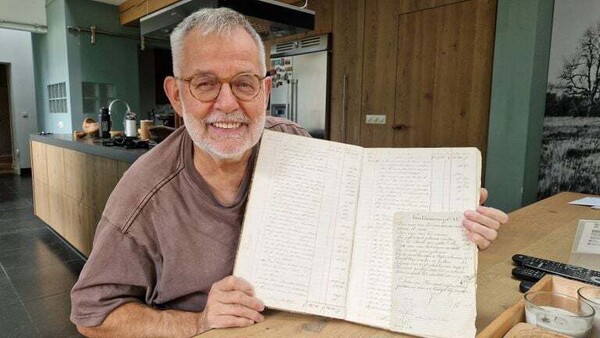 Wim Geurts met het kasboek uit de negentiende eeuw (foto: Tom Berkers)