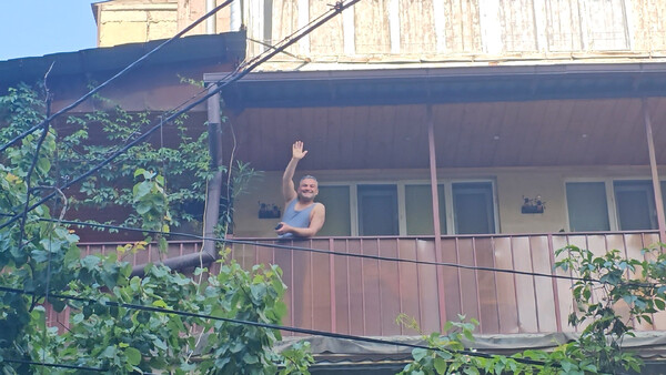 Hovsep zwaait vanaf het balkon van zijn appartement (foto: Dion van Alem)